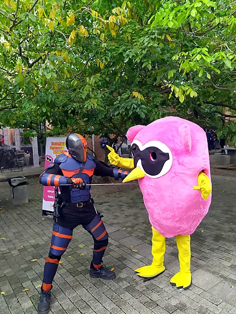 A cosplayer striking a battle pose with the Bongo owl mascot at SL Comicon 2019