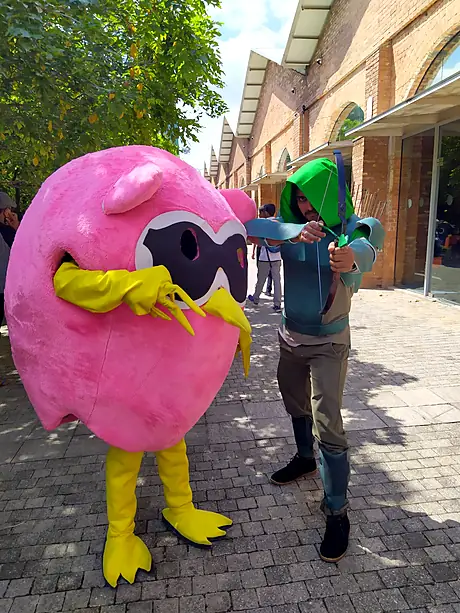 A hooded archer cosplayer with the Bongo owl mascot at SL Comicon 2019