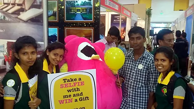 Students taking a selfie with the Bongo owl mascot at the Bongo Travel stand